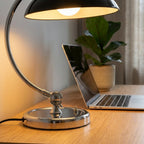 Detaljer på bordlampe med soppholde i metall i sort med sølv metall strand.