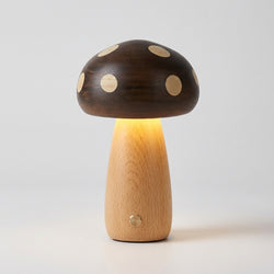 Høy sopplampe i et grått studio. Lampen er laget av ekte tre med en knapp foran. 