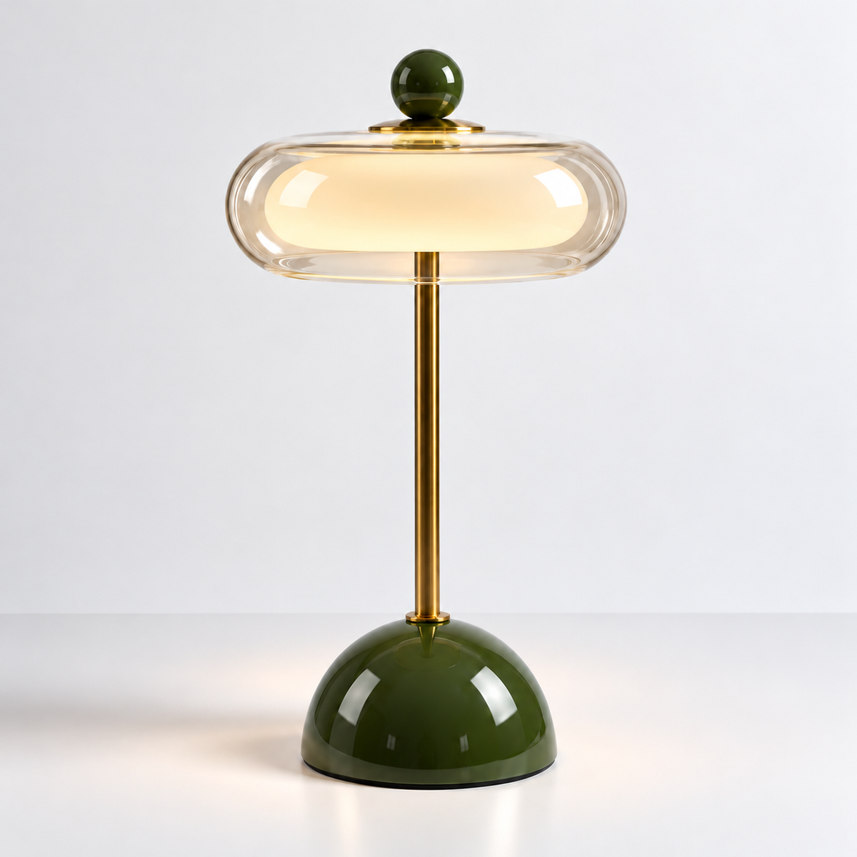Bordlampe med grønn glassfot og oval amberskjerm på hvit bakgrunn