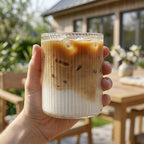 Glass med riller perfekt til iskaffe med en hånd som holder glasset. 