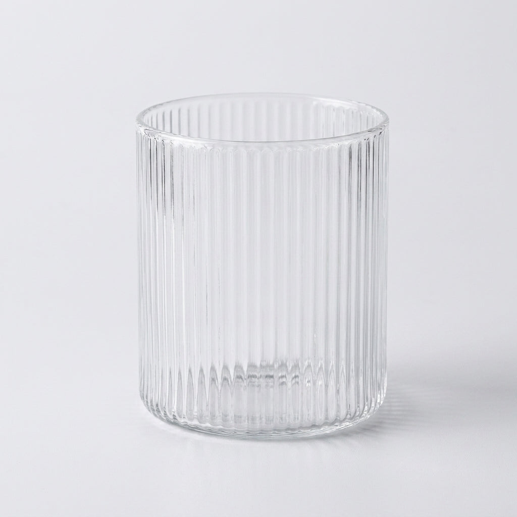 Fint glass med riller perfekt til iskaffe i et hvitt studio. 