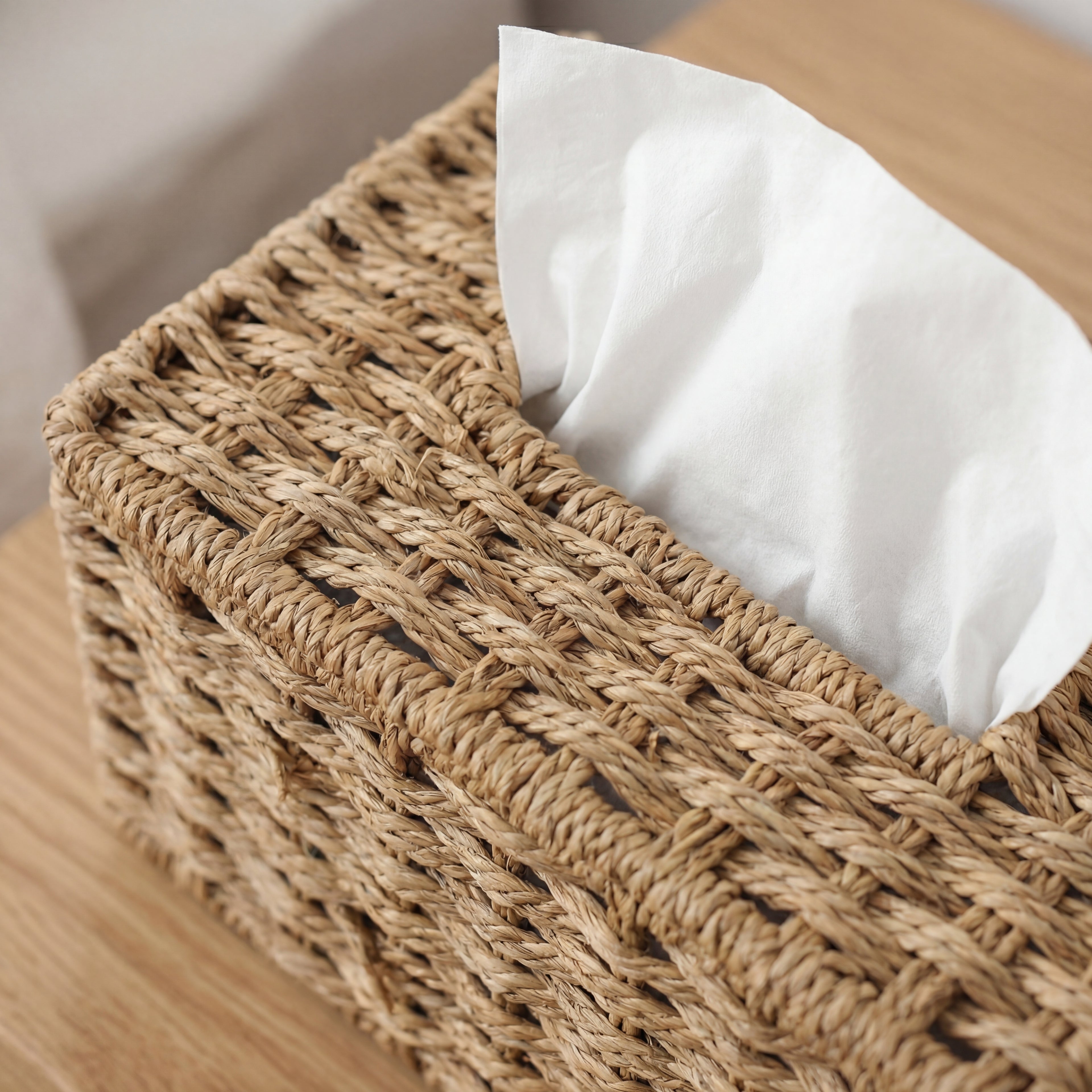 Detaljer av en fin rattan papirholder på et trebord. 