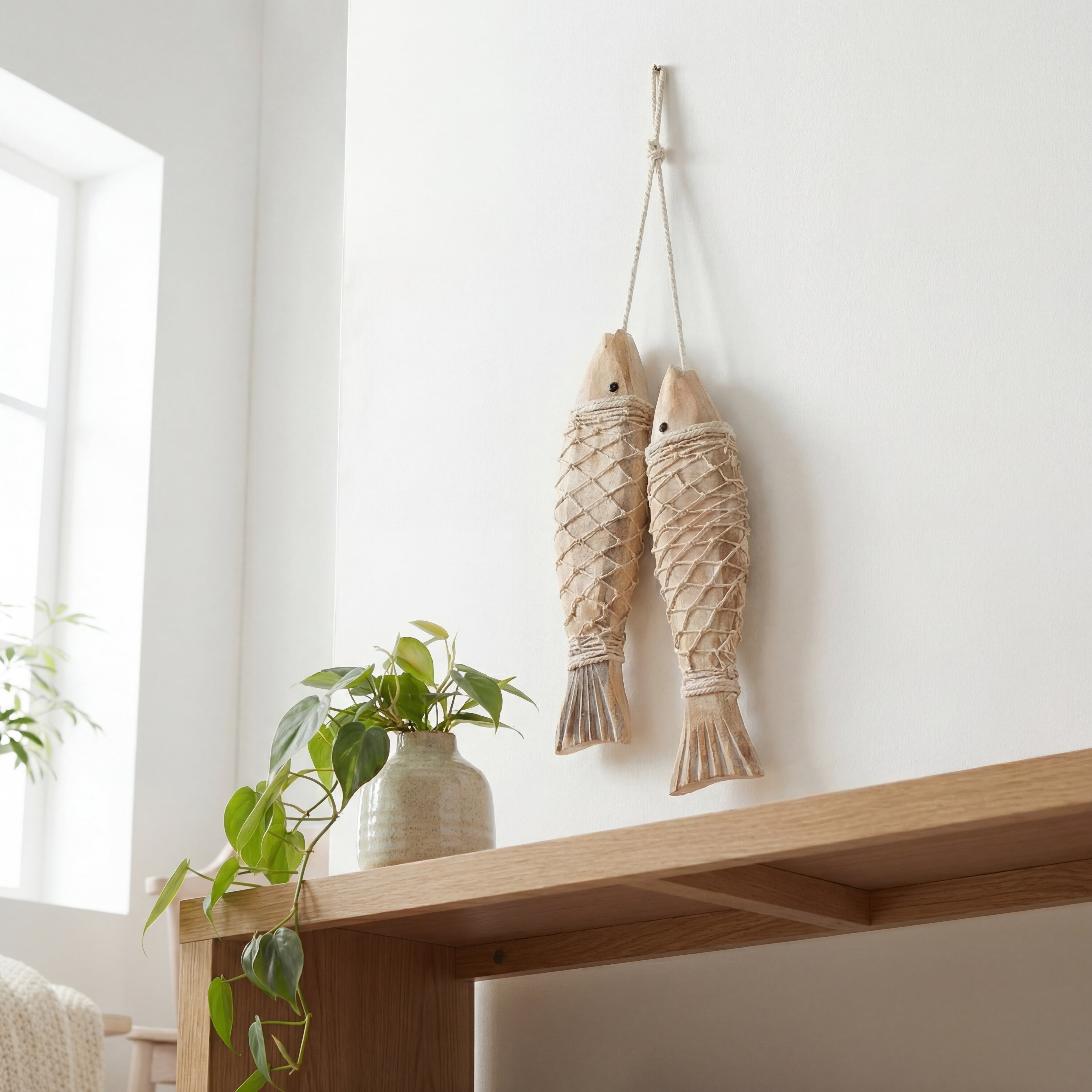 Fiske figurer i en snøring som henger på veggen. 