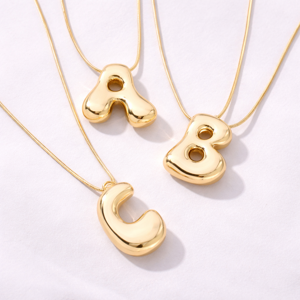 Bostav smykke i stainless steel i gull. 