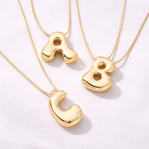 Bostav smykke i stainless steel i gull. 