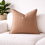 Fin khaki teksturert pute på en hvit koselig sofa