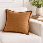 brun pute i solid farge i en hvit solid krem farget sofa. 