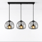 Tripple taklampe i glass i et hvitt studio.