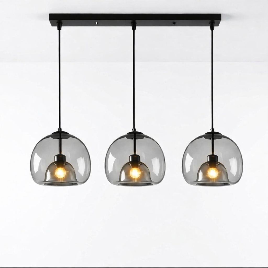 Tripple taklampe i glass i et hvitt studio.