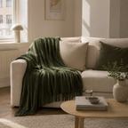 Mykt chenille pledd i grønt på en fin sofa. 