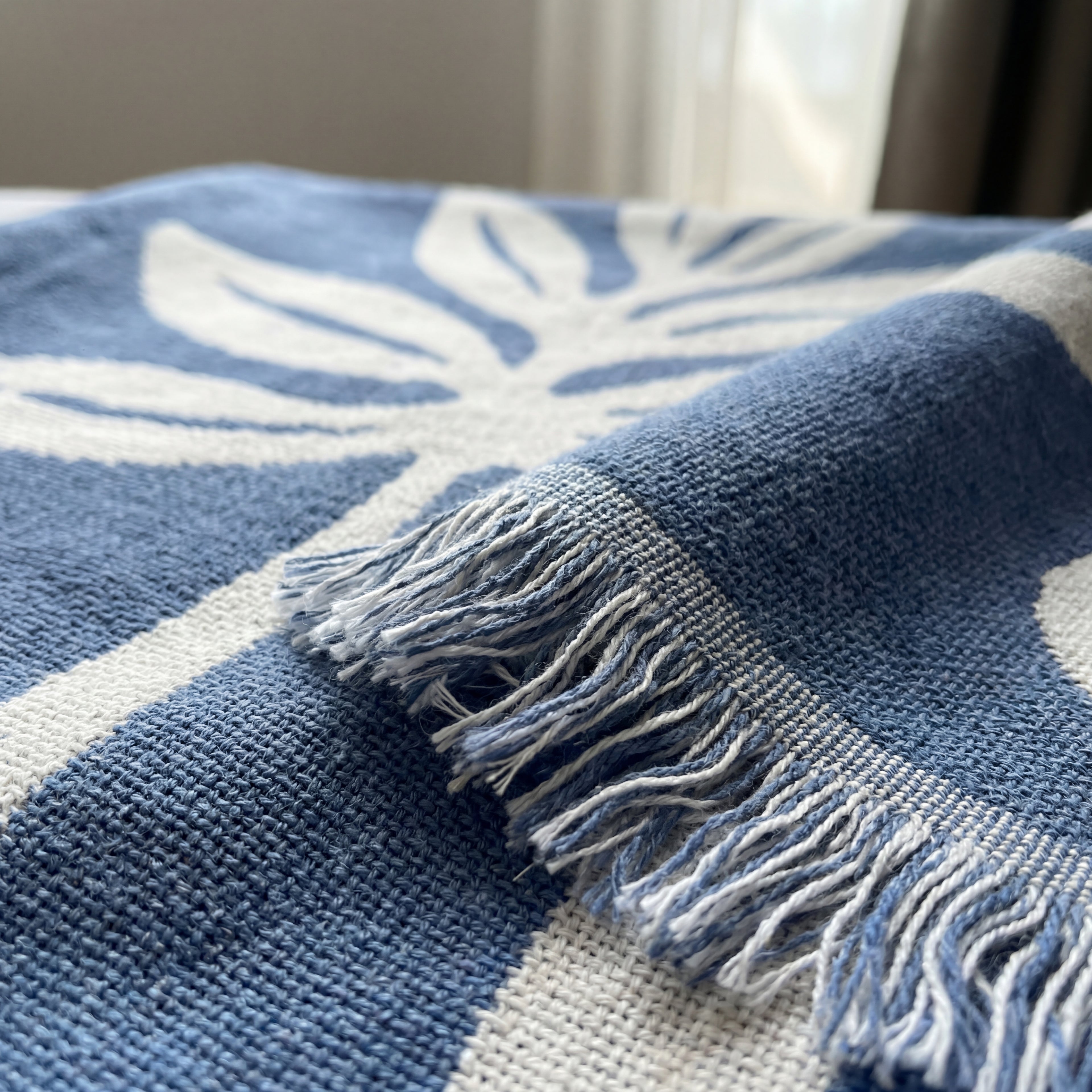 Detaljer av et stort og fint teppe i blått og hvitt. 