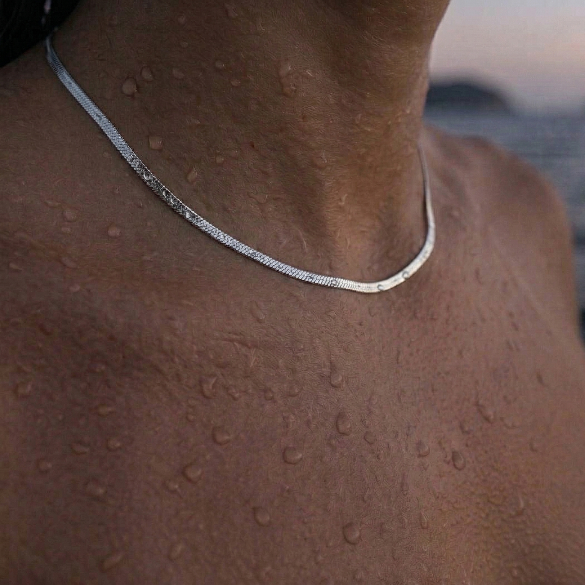 Sølv halskjede rundt modell hals.