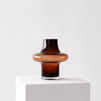 Unik glassvase i smoked brown farge i et hvitt studio. 