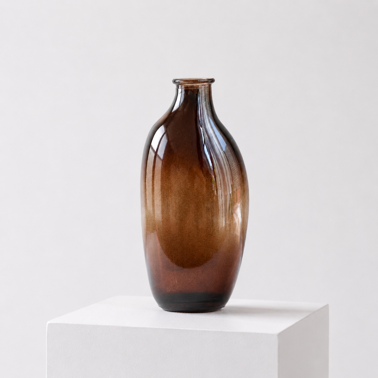 Unik brun vase i unik form i et hvitt stduio. . 