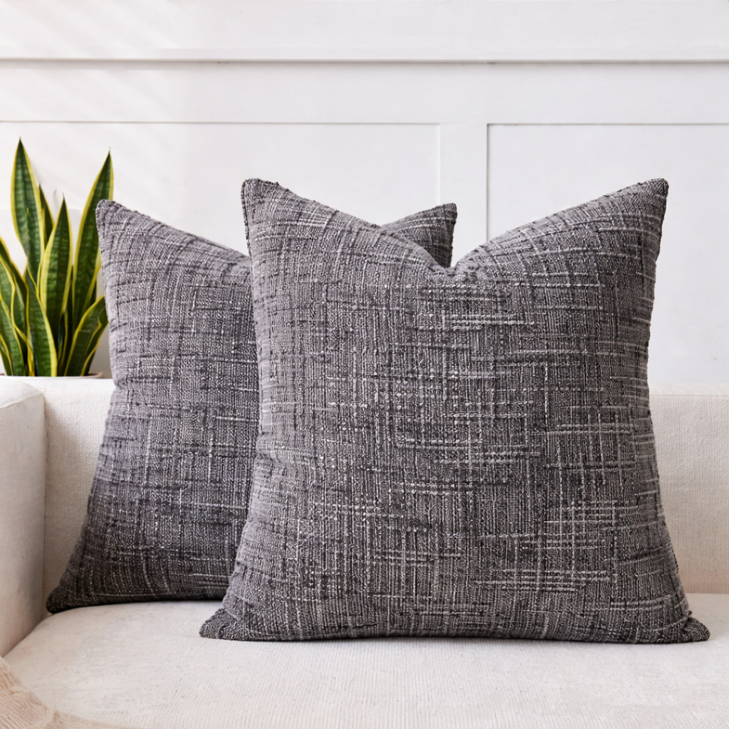 To fine grå teksturerte putetrekk i sofa