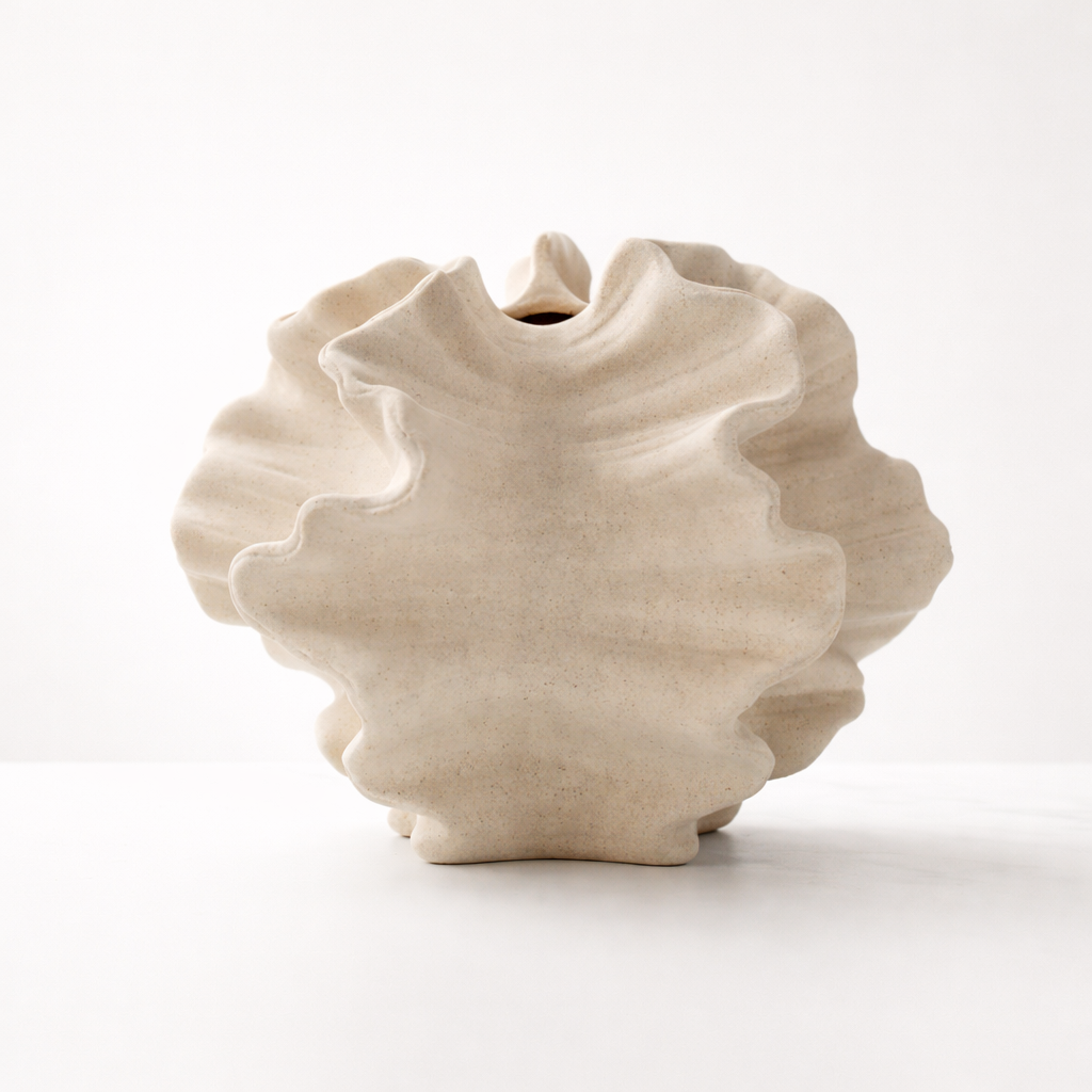 Stor vase i beige i kul form i et hvitt studio. 