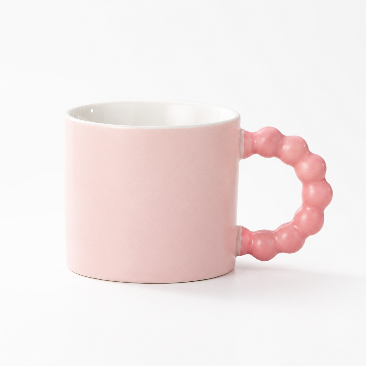 Pink coffee cup in a white studio