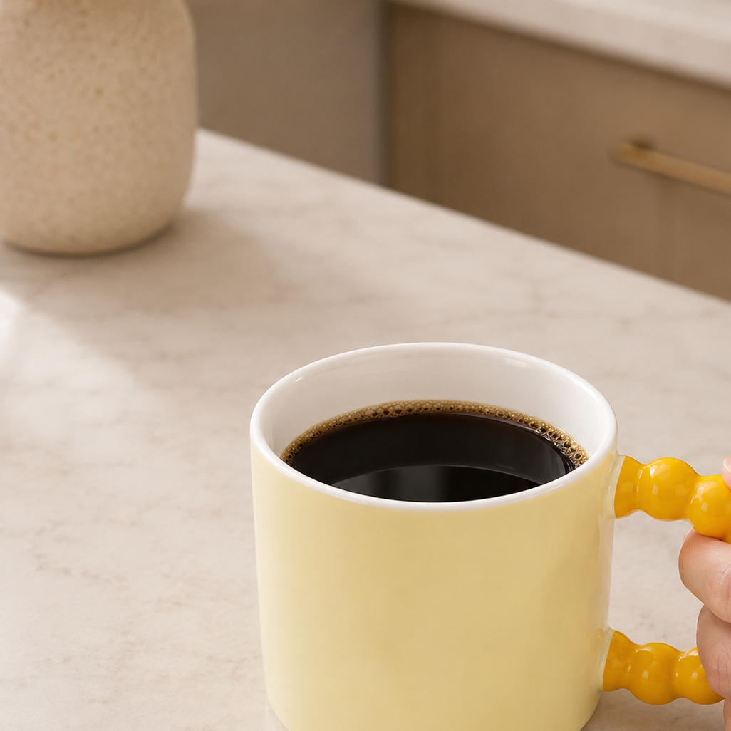 kaffekopp i gul på kjøkken.