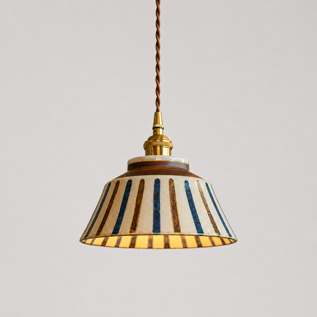 Keramikk taklampe med striper i antikk design i et prof studio. 