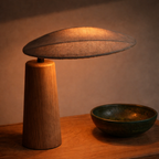 Lampe i tre med stoff hodet i et mørkt rom.
