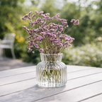 Liten vase med søte lilla blomster.