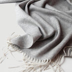 Light grey ullpledd i ull og cashmere i et studio. Tynt fint pledd til vinteren i herringbone/fiskebensmønster. 