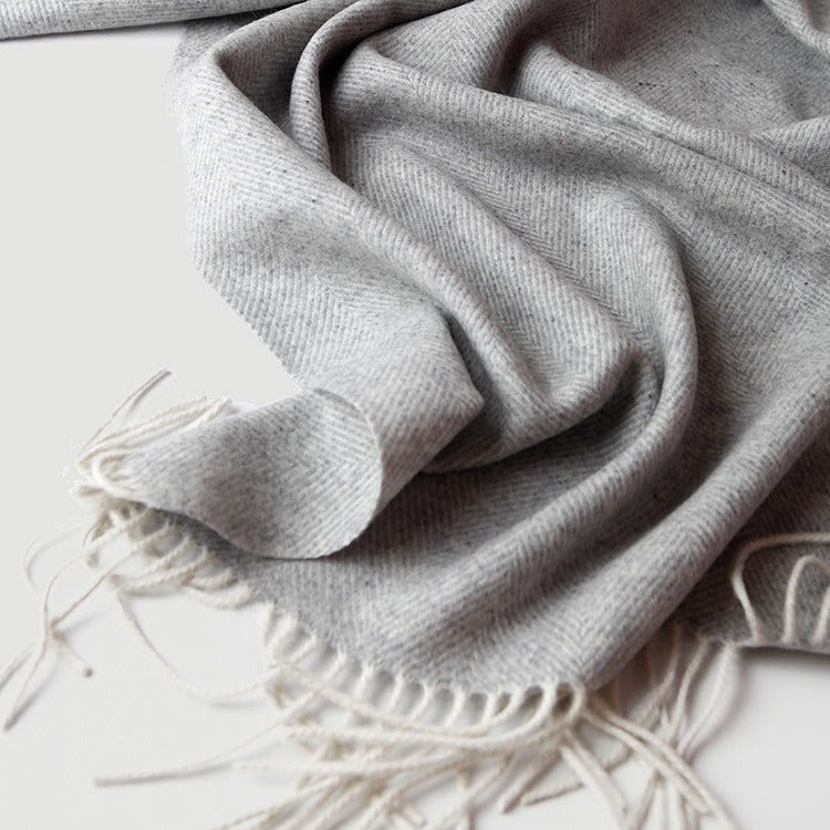 Light grey ullpledd i ull og cashmere i et studio. Tynt fint pledd til vinteren i herringbone/fiskebensmønster. 