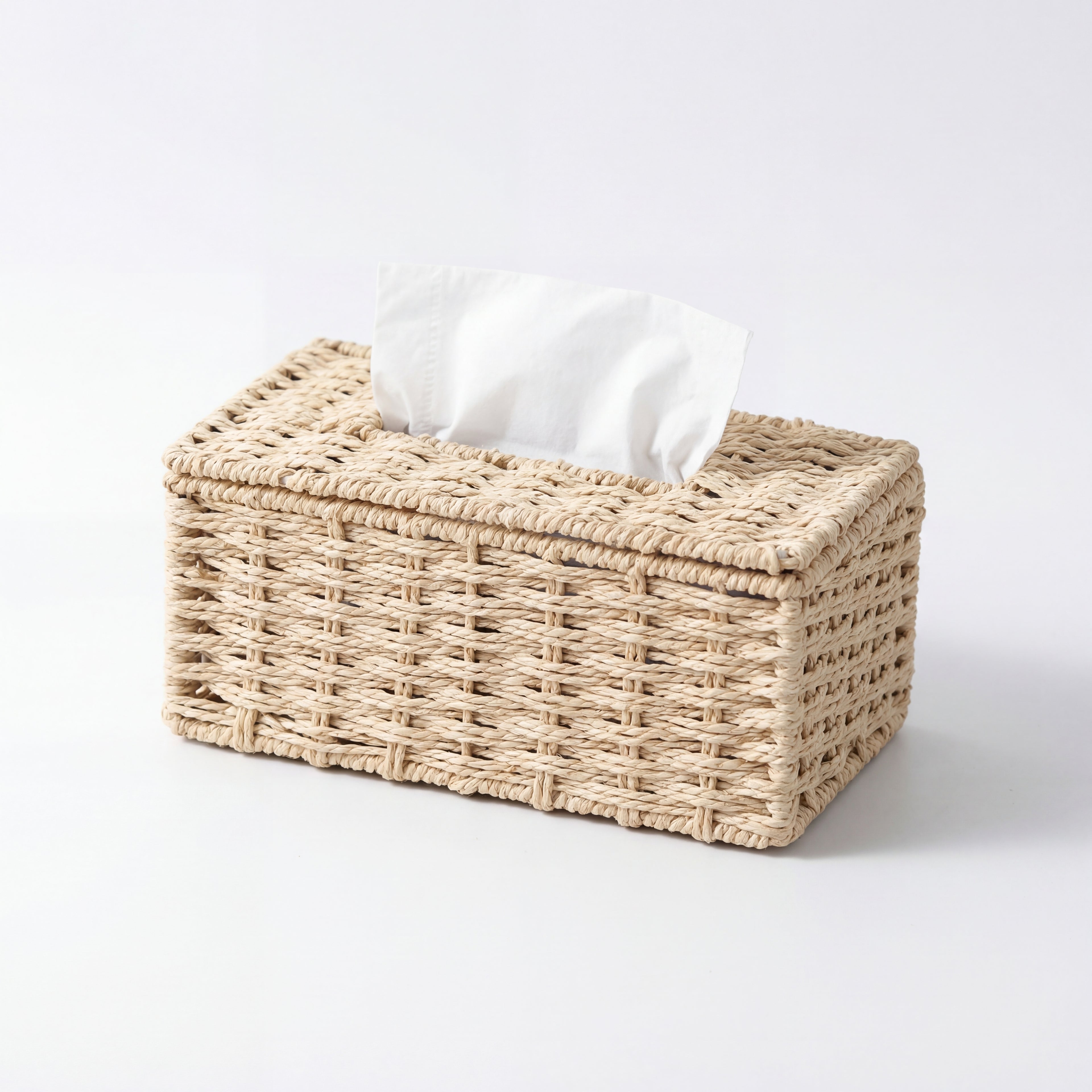 Tørkepapirholder med papir inni i en fin rattan farge i et hvitt studio.