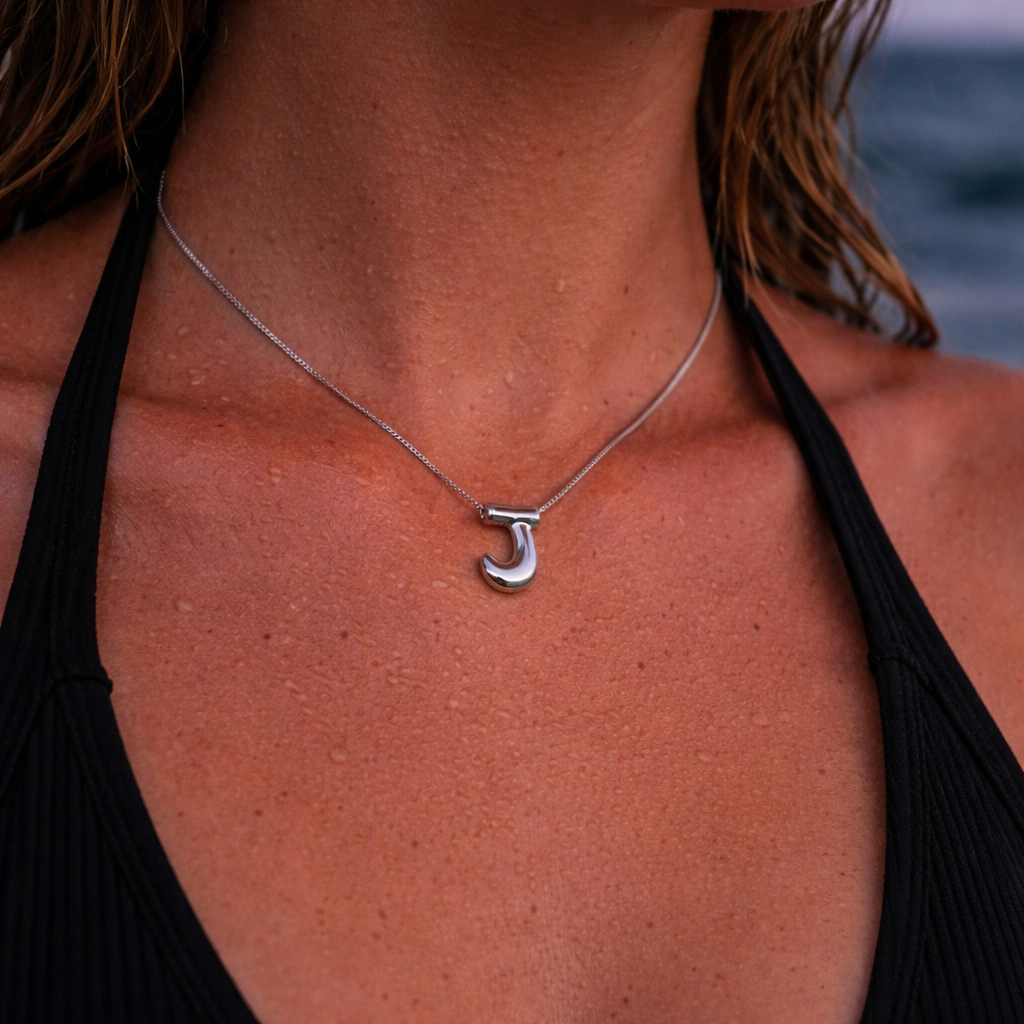 Modell med J bokstav smykke. 