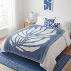 Stort og fint maritimt teppe på en fin seng. 