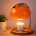 Oransje lampe med et lite lys under på et nattbord. 