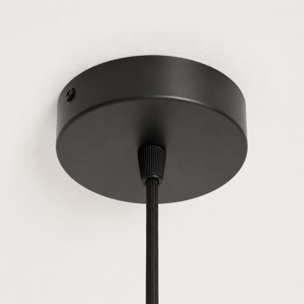 Closeup of ceiling attachment in black in a white studio. 