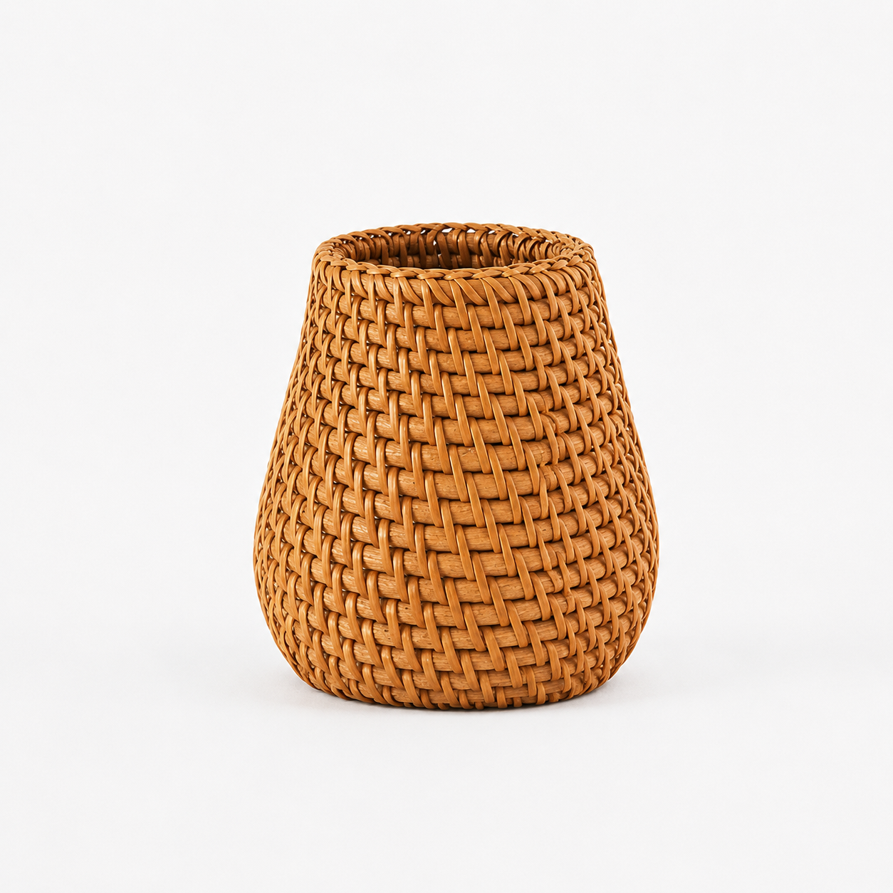 Rattan pennorganiseringsbeholder i et hvitt studio. 