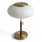 Lampe med glass, metall- og tredetaljer i et hvitt studio. 