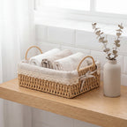 Fin liten basket i jute i et bad med brettede kleder oppi.