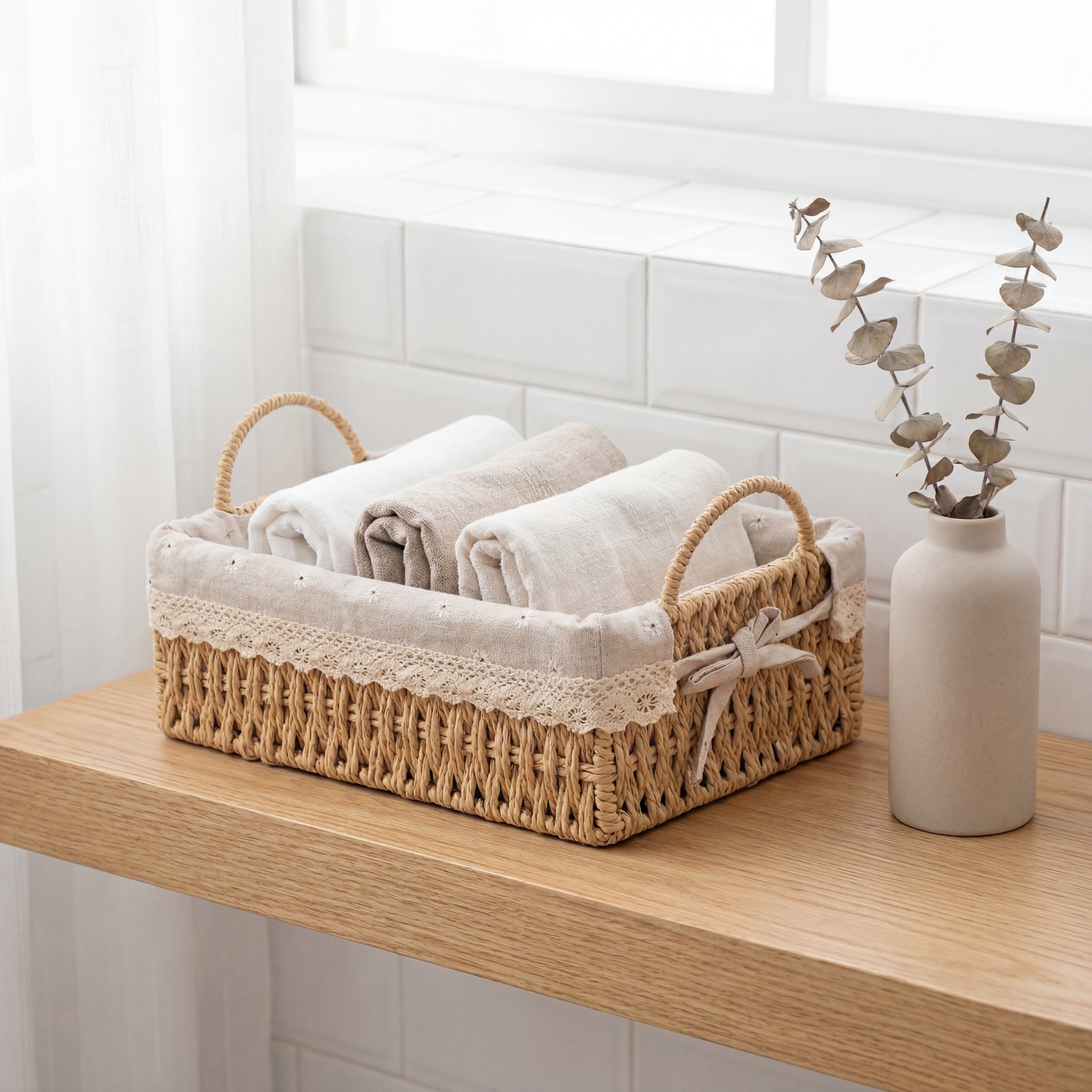 Fin liten basket i jute i et bad med brettede kleder oppi.