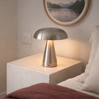 Silver lamp next to a bed. 