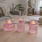 Rosa lysestaker med telys inni på stuebord.