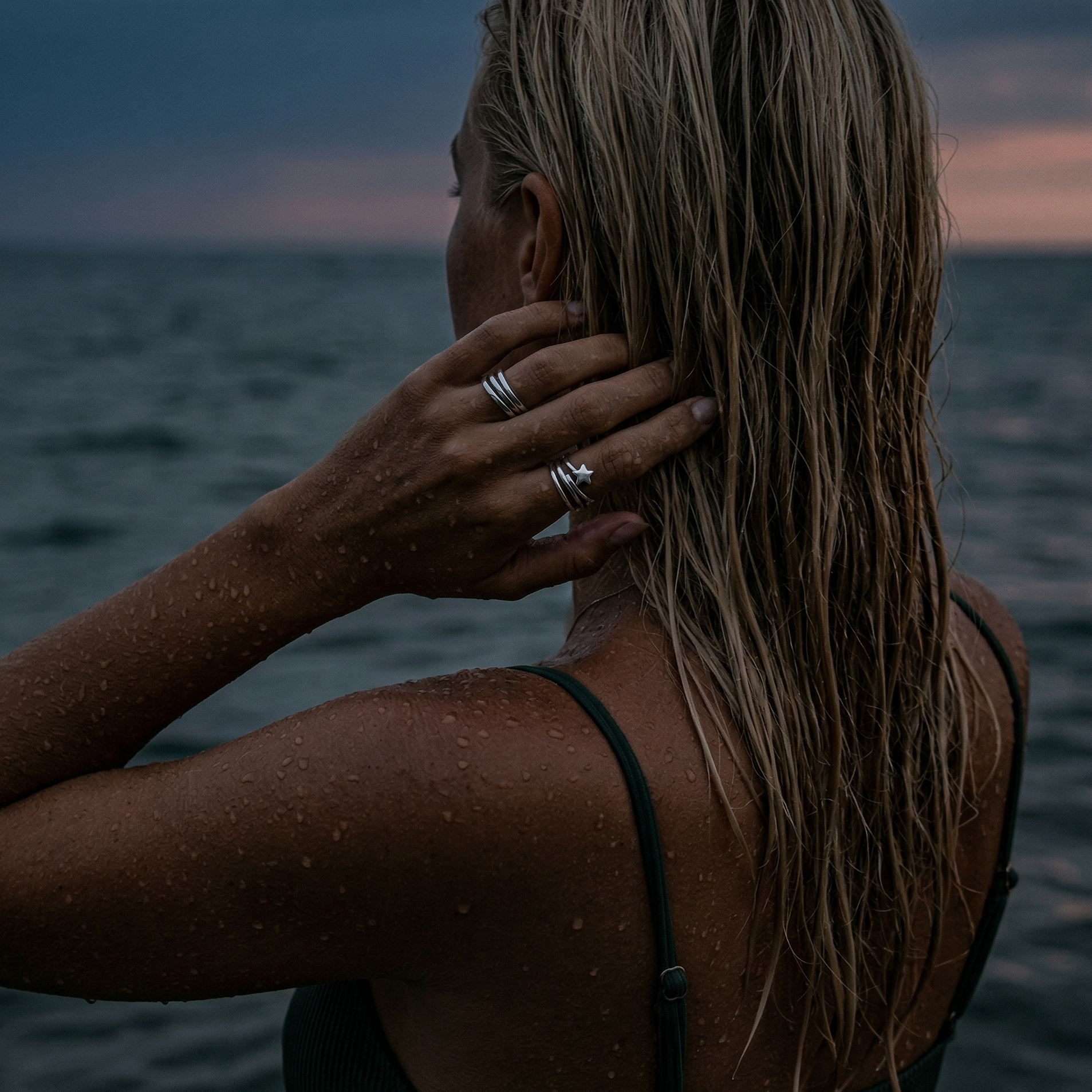 Sølv ringer på blond modell i havet. 