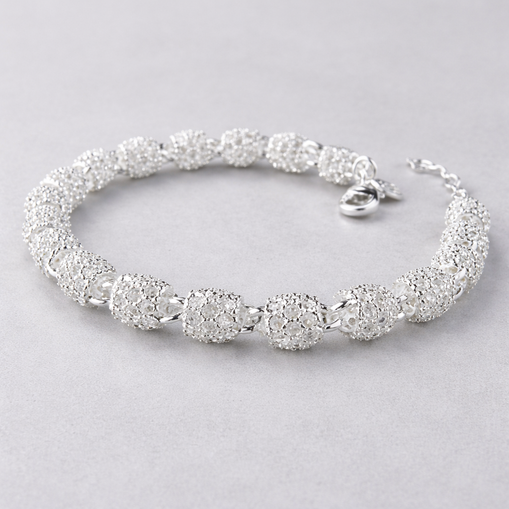 Sølv armbånd i et grått studio. 