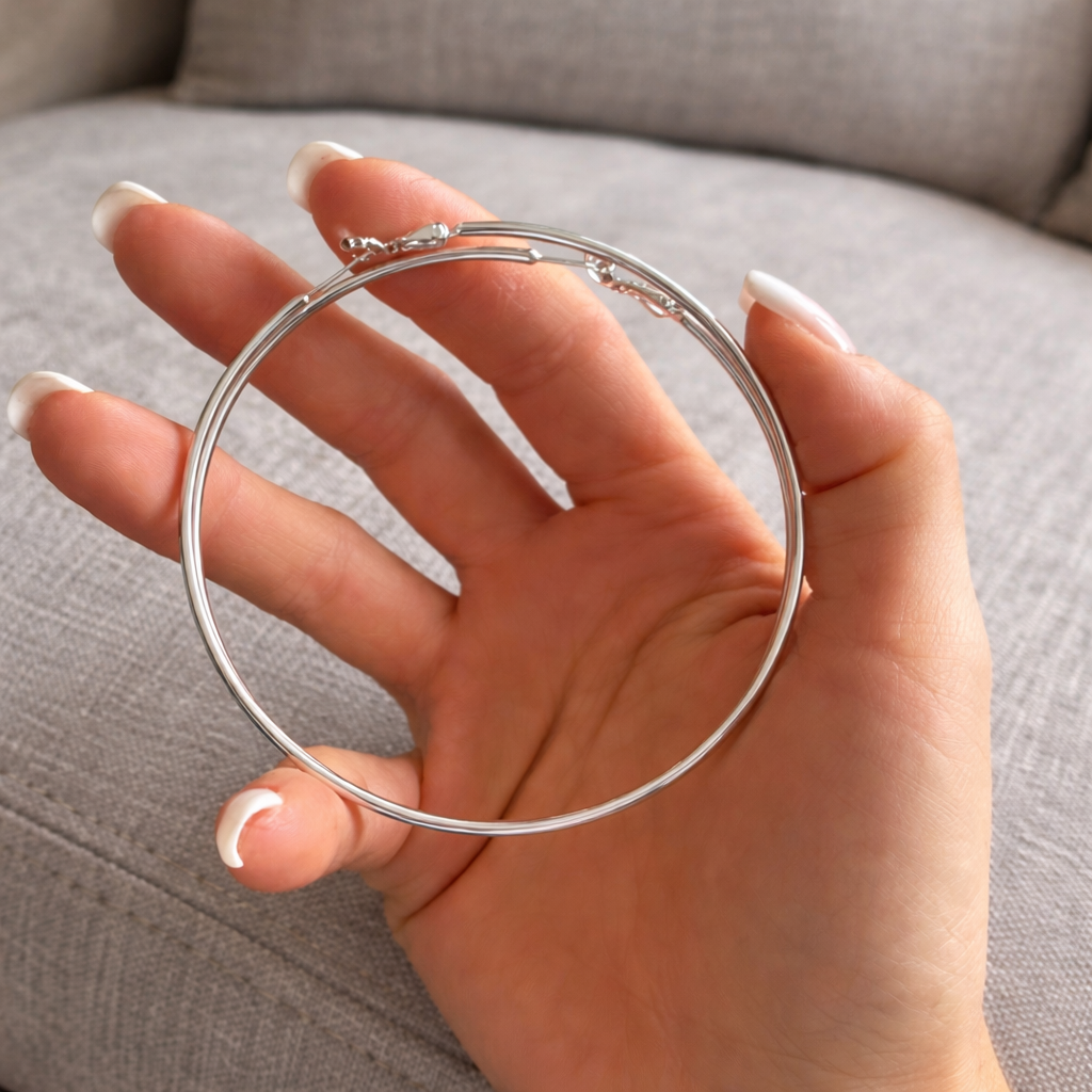 Store sølv hoops i en hånd. 