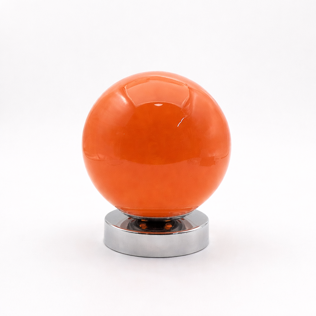 Rund oransje lampe i et hvitt studio. 