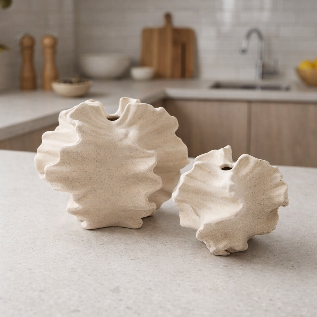To beige vaser i kule former på kjøkkenbenken. 