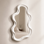 White frame small mirror on a wall