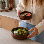 Rund brödbulle med sallad och frukostblandning i, och en flicka som håller den.