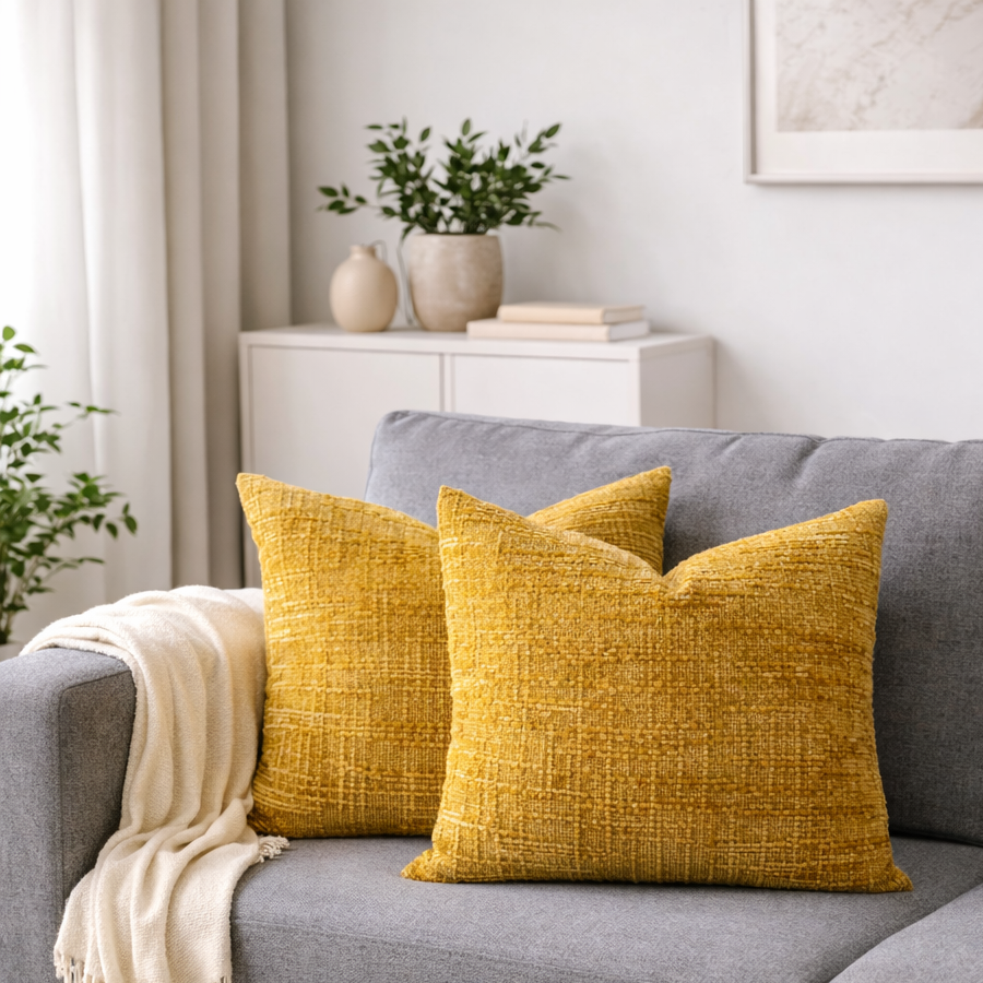 To orange fine pute på en grå sofa. 